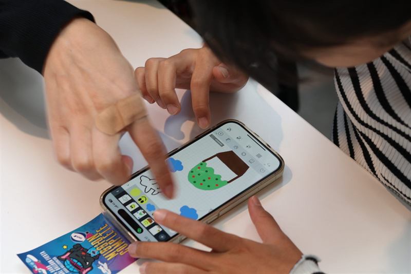 スマートフォンに気球のイラストを描く手元