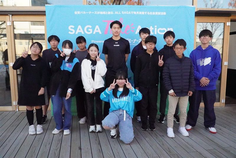 SAGA Take Actionのバナーの前に並ぶ中学生と選手